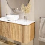Rundes wandhängendes Badmöbel 120 cm aus Natureiche mit Riffelfront und weißes Solid-Surface-Becken mit einem Waschbecken