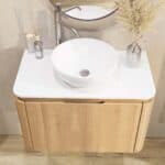 Rundes wandhängendes Badezimmermöbel 80 cm aus Natureiche mit glatte Front und weißes Solid-Surface-Becken