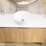 Rundes wandhängendes Badmöbel 120 cm aus Natureiche mit glatte Front und weißes Solid-Surface-Becken mit einem Waschbecken
