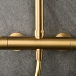 Luxuriöses Aufputz-Duschsystem in gebürstetem Gold mit PVD-Beschichtung, thermostatischer Duscharmatur und Kopfbrause Ø20 cm. Inklusive verstellbarer Handbrause. Erhältlich in 6 Farben und mit 5 Jahren Garantie.
