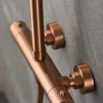 Stilvolles Aufputz-Duschsystem in gebürstetem Kupfer mit PVD-Beschichtung, thermostatischer Duscharmatur und Kopfbrause Ø20 cm. Inklusive verstellbarer Handbrause. Erhältlich in 6 Farben und mit 5 Jahren Garantie.