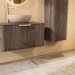 Rundes hängendes Badezimmermöbel 80 cm aus dunkler Eiche mit Riffelfront, Eichenholzplatte und beige Kalksteinbecken