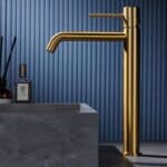 Moderne erhöhte Waschtischarmatur in Gebürstetes Gold, ideal für Badmöbel mit Aufsatzwaschbecken, als Komplettset inklusive passendem Click-Clack-Verschluss mit langlebiger PVD-Beschichtung. Der Click-Clack-Verschluss lässt sich durch Drücken einfach öffn