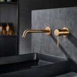 Moderne Waschtischarmatur Wandmontage in Gebürstetes Gold, für die Montage über Waschtisch oder Aufsatzwaschbecken, als Komplettset inklusive passendem Click-Clack-Verschluss mit langlebiger PVD-Beschichtung. Der Click-Clack-Verschluss lässt sich durch Dr