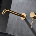 Moderne Waschtischarmatur Wandmontage in Gebürstetes Gold, für die Montage über Waschtisch oder Aufsatzwaschbecken, als Komplettset inklusive passendem Click-Clack-Verschluss mit langlebiger PVD-Beschichtung. Der Click-Clack-Verschluss lässt sich durch Dr
