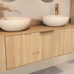 Rundes hängendes Badmöbel 120 cm aus Natureiche mit glatter Front, Eichenholzplatte und zwei beige Kalksteinbecken