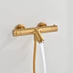Thermostatische Bad-/Duscharmatur in Gebürstetes Gold, geliefert als Komplettset mit Handbrause, Brauseschlauch und Wandhalter. Mit 5 Jahren Garantie und in 6 Farben erhältlich. Charakteristisch für die Toscana Serie ist das gedrehte Relief an der Bedienu