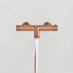 Thermostatische Bad-/Duscharmatur in Gebürstetes Kupfer, geliefert als Komplettset mit Handbrause, Brauseschlauch und Wandhalter. Mit 5 Jahren Garantie und in 6 Farben erhältlich. Charakteristisch für die Toscana Serie ist das gedrehte Relief an der Bedie