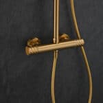 Luxuriöses Aufputz-Duschsystem in gebürstetem Gold mit PVD-Beschichtung, thermostatischer Duscharmatur und Kopfbrause Ø20 cm. Inklusive Handbrause. Erhältlich in 6 Farben und mit 5 Jahren Garantie. Charakteristisch für die Toscana Serie ist das gedrehte R