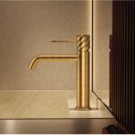 Moderne niedrige Waschtischarmatur in Gebürstetes Gold, passend für Badmöbel mit Waschtisch. Mit langlebiger PVD-Beschichtung. Mit 5 Jahren Garantie und in 6 Farben erhältlich. Charakteristisch für die Toscana Serie ist das gedrehte Relief an der Bedienun