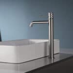 Moderne erhöhte Waschtischarmatur in Gebürstetes Nickel, ideal für Badmöbel mit Aufsatzwaschbecken. Mit 5 Jahren Garantie und in 6 Farben erhältlich. Charakteristisch für die Toscana Serie ist das gedrehte Relief an der Bedienung: ein dezentes Muster, das