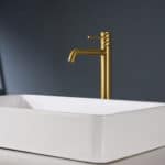 Moderne erhöhte Waschtischarmatur in Gebürstetes Gold, ideal für Badmöbel mit Aufsatzwaschbecken. Mit langlebiger PVD-Beschichtung. Mit 5 Jahren Garantie und in 6 Farben erhältlich. Charakteristisch für die Toscana Serie ist das gedrehte Relief an der Bed