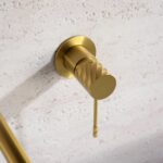 Moderne Waschtischarmatur Wandmontage in Gebürstetes Gold, für die Montage über Waschtisch oder Aufsatzwaschbecken. Mit langlebiger PVD-Beschichtung. Mit 5 Jahren Garantie und in 6 Farben erhältlich. Charakteristisch für die Toscana Serie ist das gedrehte