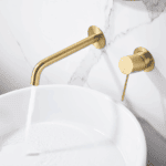 Moderne Waschtischarmatur Wandmontage in Gebürstetes Gold, für die Montage über Waschtisch oder Aufsatzwaschbecken, als Komplettset inklusive passendem Click-Clack-Verschluss mit langlebiger PVD-Beschichtung. Der Click-Clack-Verschluss lässt sich durch Dr