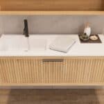 Das Rosenfeld Badmöbel 120 in Natur Eiche vereint handwerkliche Präzision mit modernem Luxus. Gefertigt aus massivem Eichenholz mit Rillenfront, Softclose-Schubladen und einem matten weißen Mineralwerkstoff-. Das Waschbecken ist wahlweise mit oder ohne Ha