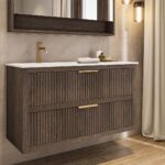 Das Rosenfeld Badmöbel 120 in Eiche dunkel strahlt Luxus und Ruhe aus. Gefertigt aus massivem Eichenholz mit Rillenfront, zwei hochwertigen Softclose-Schubladen und einem matten weißen Mineralwerkstoff- mit Überlauf. Das Waschbecken ist wahlweise mit oder
