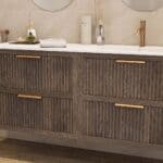 Das Rosenfeld Badmöbel 160 in Eiche dunkel strahlt Luxus und Ruhe aus. Gefertigt aus massivem Eichenholz mit Rillenfront, vier hochwertigen Softclose-Schubladen und einem matten weißen Mineralwerkstoff- mit Überlauf. Das Waschbecken ist wahlweise mit oder